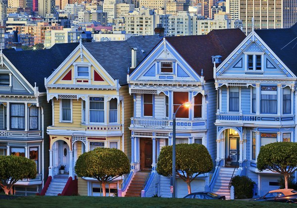 A row of painted Victorian houses on a city street