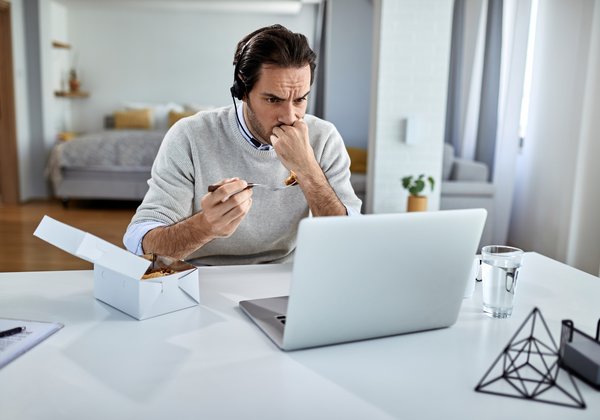 A man at a laptop looking worried at what he is reading